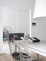 Bright dining area with wooden table and chairs, view into the living room