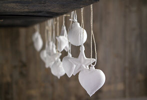 White hearts and stars on strings against a wooden background