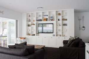 Living room with built-in shelving, TV and dark sofa