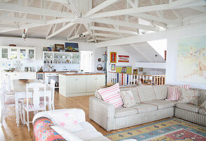 Bright living room with open-plan kitchen, white beams and vintage decor