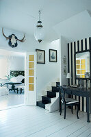 Schwarz-weiß gestalteter Raum mit Spiegel und Treppe
