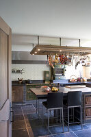 Rustic kitchen with metro tiles and hanging rack for cooking utensils