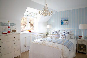 Bedroom with marine décor, striped walls and metal bed frame