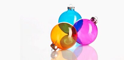 Three colourful, transparent Christmas tree baubles