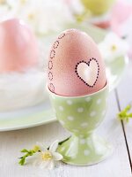Easter egg decorated with heart in eggcup