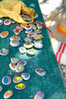 Memory game made from painted stones on a bench in the garden