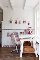 Weißer, verstellbarer Schreibtisch mit Schreibtischstuhl und Schaffell vor kreativer Wanddekoration und kunsthandwerklichen traditionellen Wandfliesen