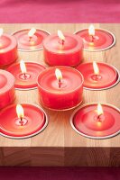 Red tealights on and in wooden board