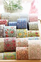 Rolls of woven ribbons with floral motifs in various colours