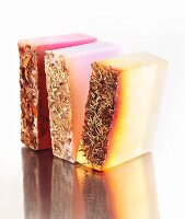 Hand Crafted Natural Soaps on a Reflective Surface; Rose, Lavender and Rosemary Mint