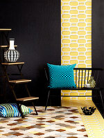 Bench with blue cushion and shelves in front of black wall with strip of yellow wallpaper