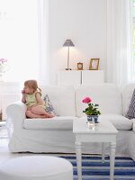 Little girl sitting on sofa in living room