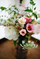 Bouquet of spring wedding flowers on top of a wine barrel in a rustic setting