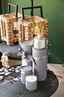 Festive arrangement of candles, presents wrapped in grey and wooden lanterns