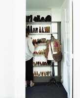 Vintage tailors' dummy in front of open-fronted shoe rack; woman standing in front of rack