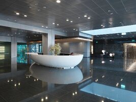 Luxurious hotel reception lobby area with recessed lights reflecting on floor