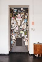 Old steel door used as magnetic pinboard for photos