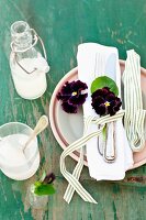 White linen napkin with cutlery and pansies