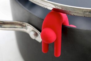 A red Lid Sid on the edge of a pan