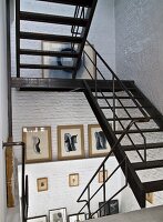 Metal staircase in stairwell with whitewashed brick walls