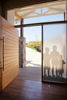 Entrance area with wooden door, frosted glass panes and children's shadows