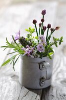 Freshly-picked, flowering herbs in metal mug