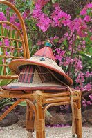 Painted straw hats on bamboo chair outdoors