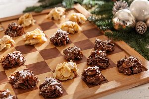 Helle und dunkle Schokocrispies auf Schachbrett und Weihnachtsdeko