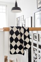 A hand-knitted black and white checked blanket made of Merino yarn