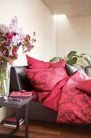 Bedroom with flowers on bedside table and red accents