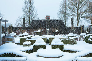 Formal garden in winter, with box hedges covered in snow