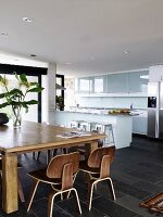 Wooden table and classic chairs in open-plan kitchen-dining room