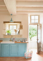 Light blue kitchen base units with sink in country-house kitchen