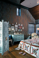 Vintage furniture in bedroom with dark ornate wallpaper