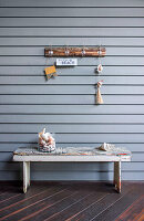 Rustic wooden bench and wall hooks with maritime decoration