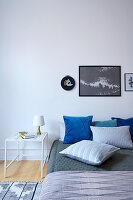 Bedspread and scatter cushions on double bed in simple bedroom