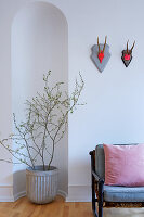 Potted plant in arched niche next to couch with seat cushions and scatter cushions