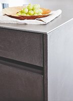 Kitchen drawers with concrete-look fronts and a steel worktop