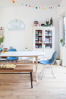 Dining table, chairs and bench in front of vintage bookcase