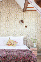Double bed in bedroom with retro wallpaper