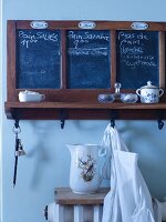 Chalkboards and hooks for weekly planning on old wall-mounted shelf