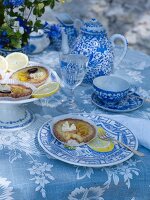 Table set with blue-patterned crockery and tarts