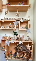 Christmas decorations and nativity scene in wooden boxes on wall