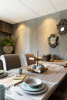 Table set in natural shades in dining room with grey glazed walls