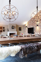 Sheepskins on bench at dining table in converted barn
