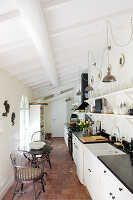 Seating area in narrow country-house kitchen with sloping wood-beamed ceiling