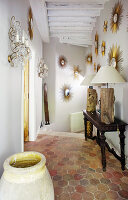 Collection of sunburst mirrors in hallway with honeycomb floor tiles