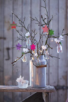 Hanging garden: Advent arrangement of stars and flowers in tiny vases hung from branches
