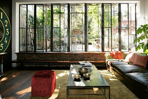 Sunny living room with glass wall overlooking roof terrace