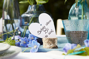 Summery table decoration with blue flowers and heart card with welcome greeting